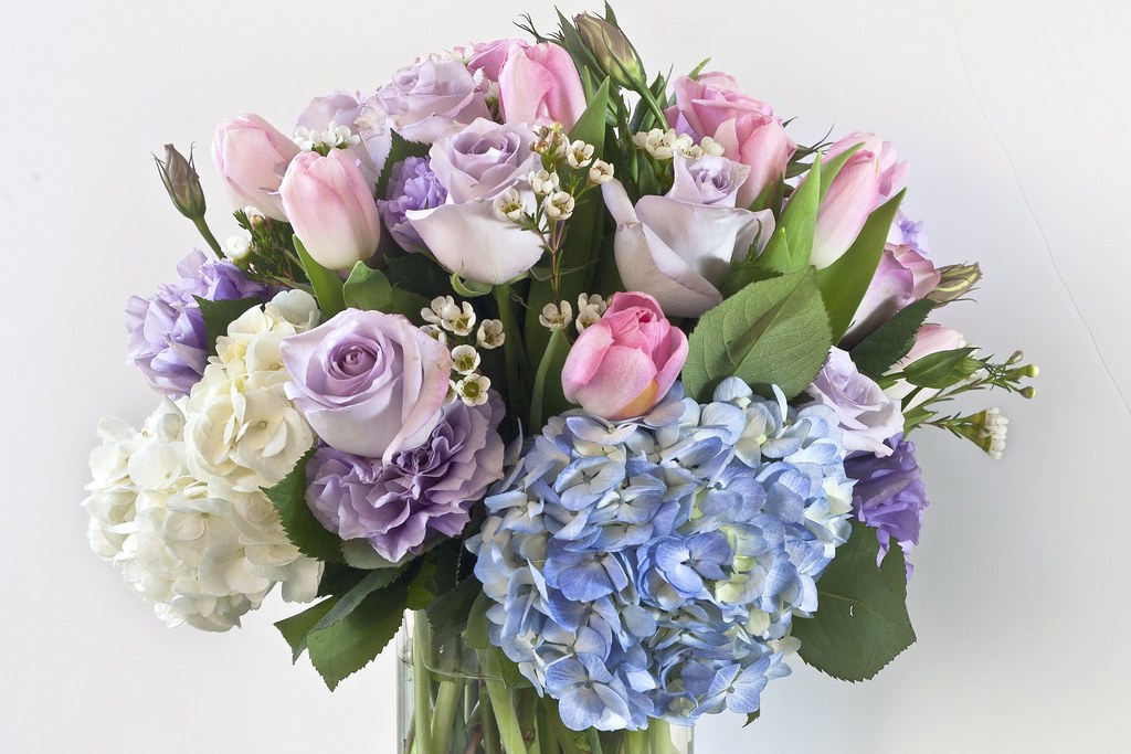 A pastel arrangement of roses, tulips, hydrangeas, and foliage